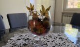 centrotavola autunnale faidate con ricci di castagna, pigne e foglie in un calice di vetro